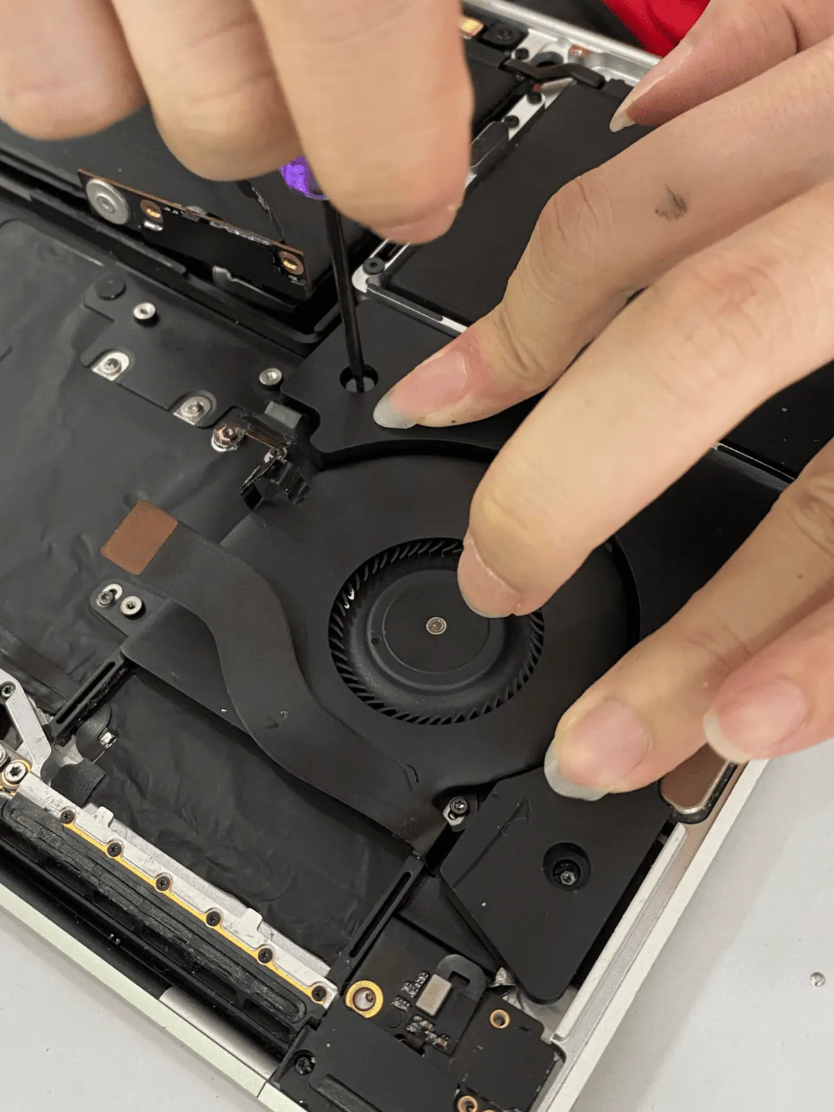 MacBook cooling fan and heatsink removed for cleaning