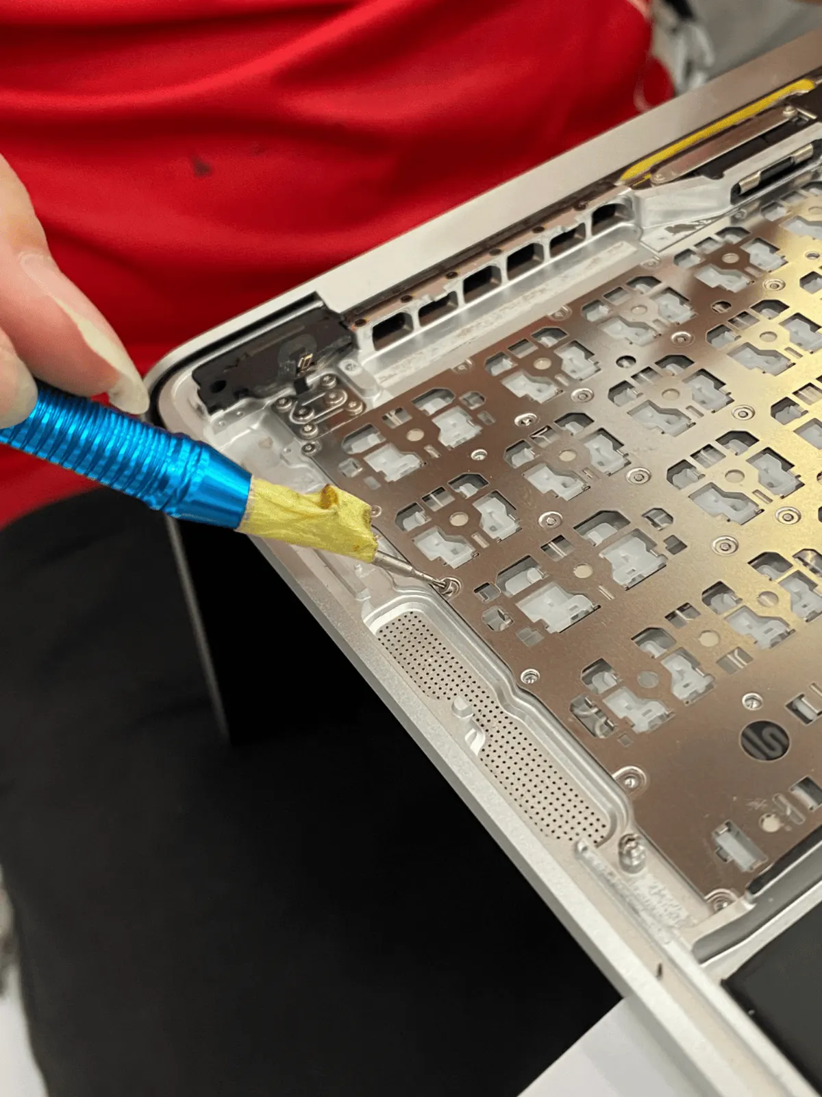 Keyboard backplate being removed from a MacBook